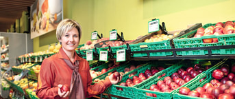 Verkaufsmitarbeiterin hält Äpfel Verkaufsmitarbeiterin hält Äpfel